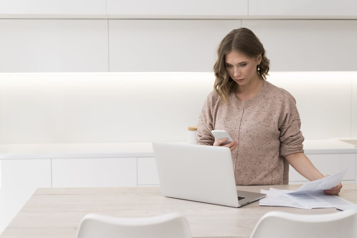 Mujer tramitando el canje del carnet por internet con su documentación delante