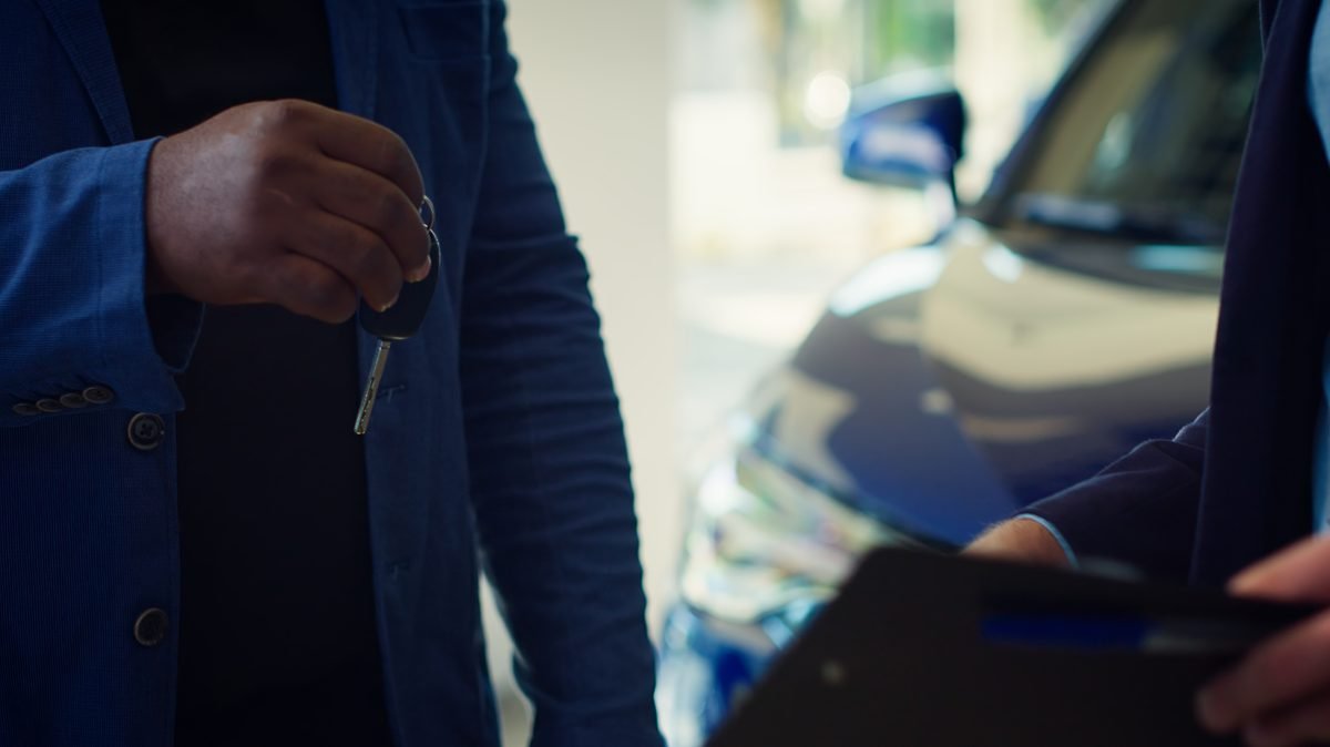 Comprador y vendedor cerrando con un apretón de manos la compraventa del coche