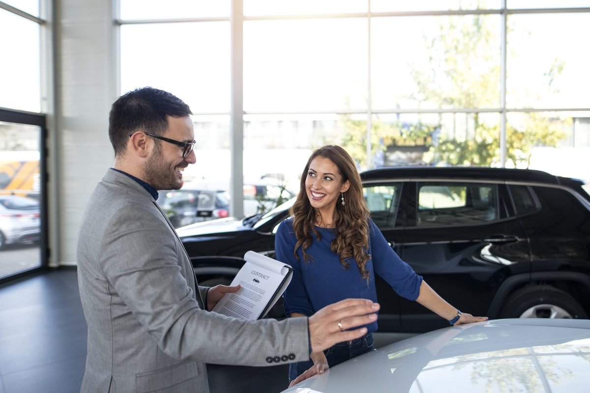 Profesional explicando a un cliente la documentación de un coche importado